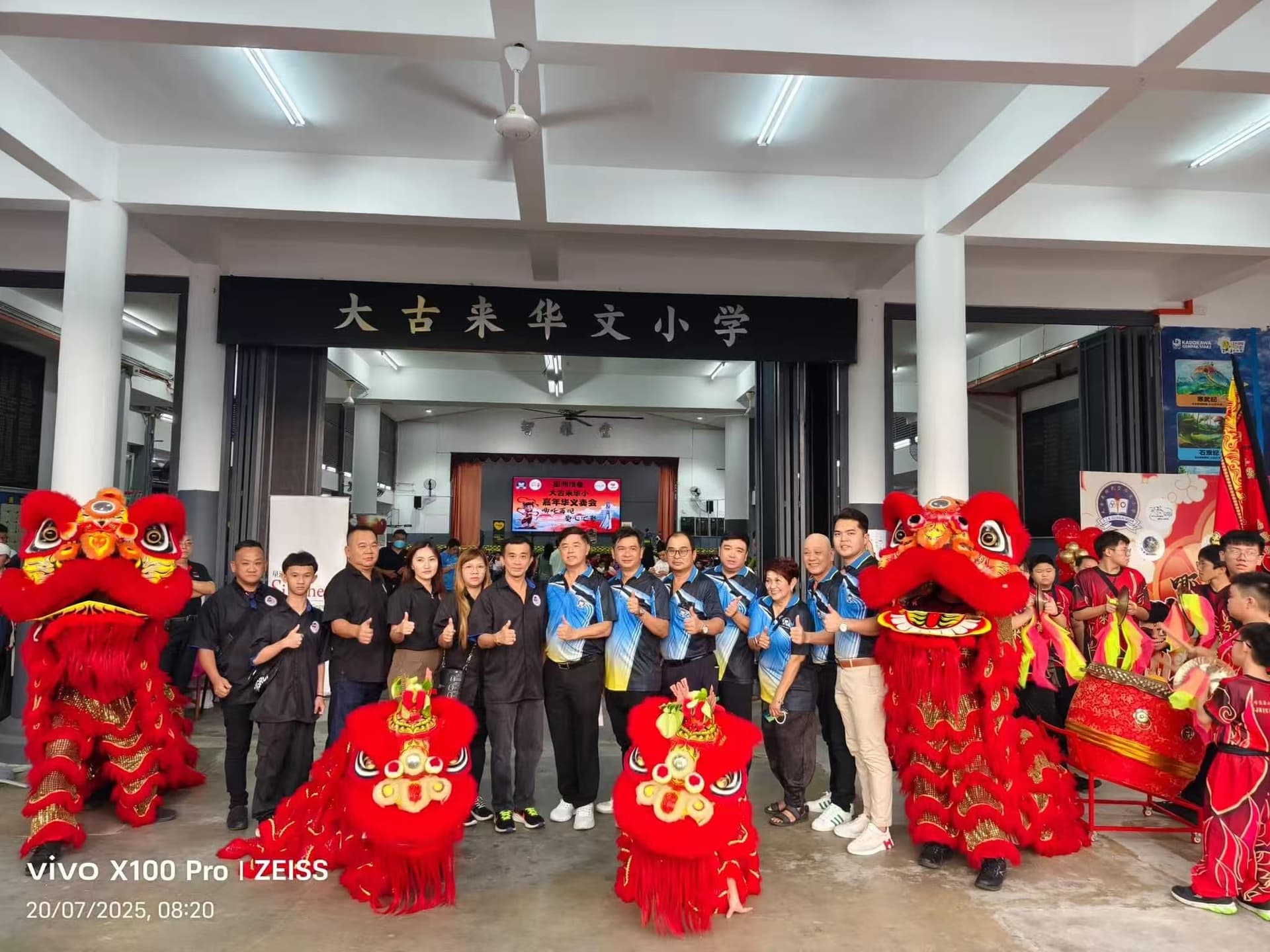 Dato' Fam Chee Way — SJKC Kulai Besar Carnival & Donation 2025 Dato' Fam Chee Way — Group photo with lion dance at SJKC Kulai Besar (大古来华文小学) carnival and donation ceremony, 20 July 2025